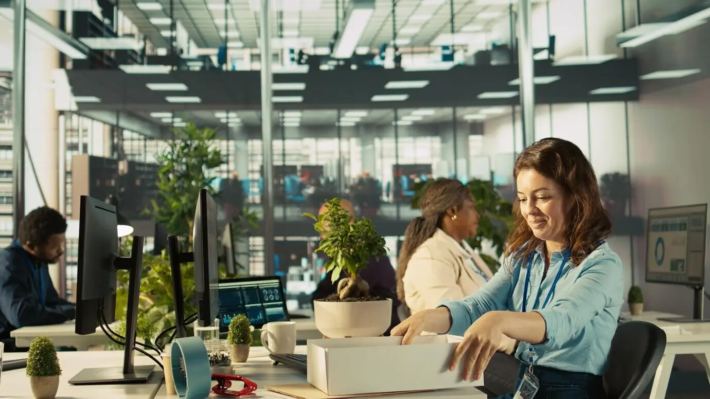 Радостный сотрудник в свой первый рабочий день распаковывает вещи и знакомится с коллегами.