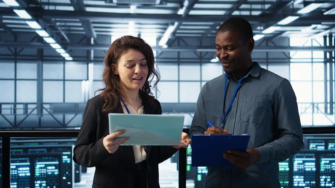 Руководители центра обработки данных читают бумажные документы.